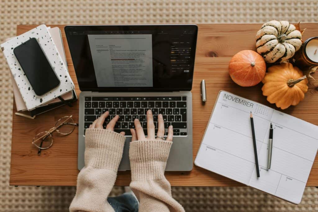 A cozy autumn-themed desk setup with a laptop and planner for productive work sessions at home.